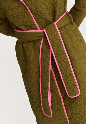 Pikowany szlafrok w oliwkowej zieleni, z motywem liści, różową lamówką i dopasowanym paskiem wiązanym. Tkanina ma teksturowany, wyściełany wygląd.