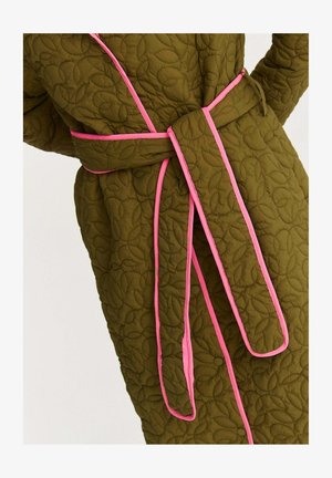 Pikowany szlafrok w oliwkowej zieleni, z motywem liści, różową lamówką i dopasowanym paskiem wiązanym. Tkanina ma teksturowany, wyściełany wygląd.