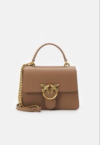 Brun läderhandväska med strukturerad form, guldfärgad fågelformad metall, kedjerem och ett överhandtag. Mjuk yta, minimalistisk design.
