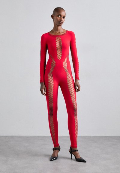Costum cu mâneci lungi, de culoare roșie, cu decupaje din plasă pe laterale și pe mâneci. Material neted, elastic, asortat cu tocuri negre.