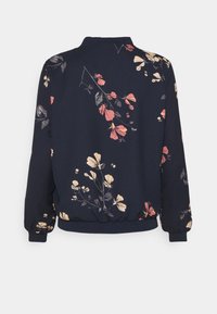 Kwiatowa kurtka bomberka z ciemnoniebieskim tłem i różowymi oraz żółtymi wzorami kwiatowymi. Wykonana z miękkiego materiału z prążkowanymi mankietami i dołem.