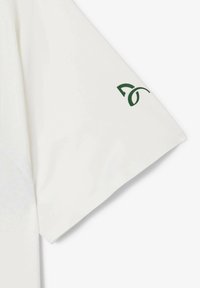 Hvid kortærmet skjorte med et buet grønt logo på venstre ærme. Stoffet har en glat og let tekstur.