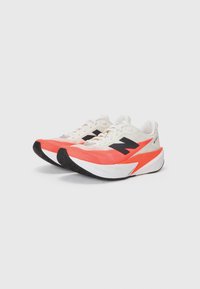 Running shoes featuring a white, black, and bright coral design, with a textured upper, cushioned midsole, and a patterned rubber outsole.
