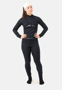Svart långärmad baslagertröja med kvartzip och bergsgrafik; kombinerad med matchande svarta figurformade leggings och huvudband.