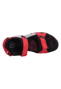 Red sandals with adjustable black straps, a cushioned black insole featuring a geometric pattern, and a sturdy black outsole.