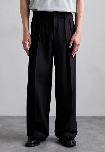 Black pleated trousers made of smooth fabric, featuring a tailored fit, wide legs, and a single button closure at the waist.
