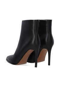 Černé kožené kotníkové boty s špičatou špičkou a vysokým, tenkým stiletto podpatkem. Obsahují boční zip a hladký povrch.