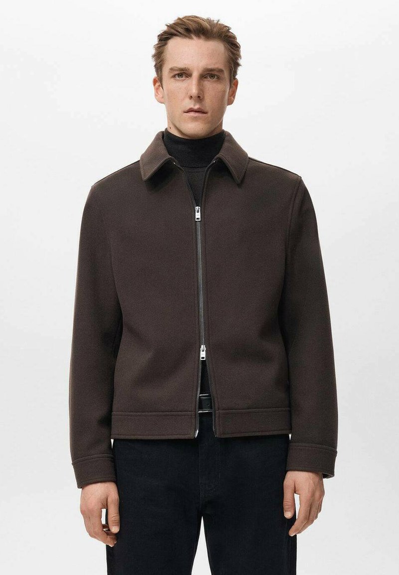 Brązowa kurtka zapinana na suwak z kołnierzem, wykonana z gładkiego materiału. Posiada zamek błyskawiczny z przodu i boczne kieszenie; zaprojektowana z minimalistycznymi akcentami.