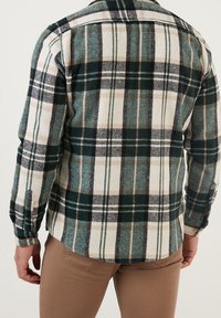 Grünes und beiges kariertes Flanellhemd mit abgerundetem Saum und Knopfmanschetten, aus strukturiertem Stoff mit Rückenteil-Detail.