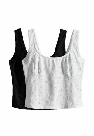 Two sleeveless crop tops with floral eyelet embroidery, one white in front and one black behind, displayed against a white background.