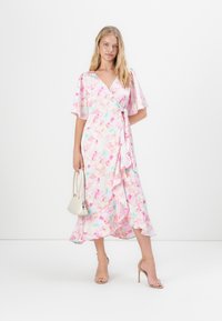 Φλοράλ φόρεμα με δέσιμο στη μέση σε ανοιχτό ροζ χρώμα με μπλε και λεβάντα λεπτομέρειες. Διαθέτει ρέουσα φούστα, κοντά φουσκωτά μανίκια και ζωνάκι για δέσιμο.