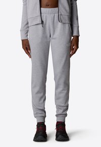 Grijze sweatpants met een elastische tailleband en taps toelopende benen, gemaakt van een zachte stof, met een subtiel logo op de zijkant.