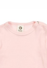 Hellrosa geripptes Material mit runder Halslinie, ausgestattet mit einem Druckknopf nahe der Schulter. Das Etikett zeigt die Marke "müsli." Weiche Textur.