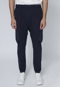 Donkerblauwe joggingbroek met een elastische tailleband, zijzakken en een taps toelopend ontwerp, gemaakt van lichtgewicht, ademend materiaal.