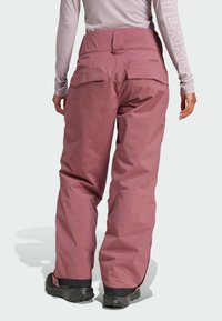 Pink snow pants made of durable fabric, featuring a straight leg design, adjustable waist, and two rear pockets. Suitable for winter activities.