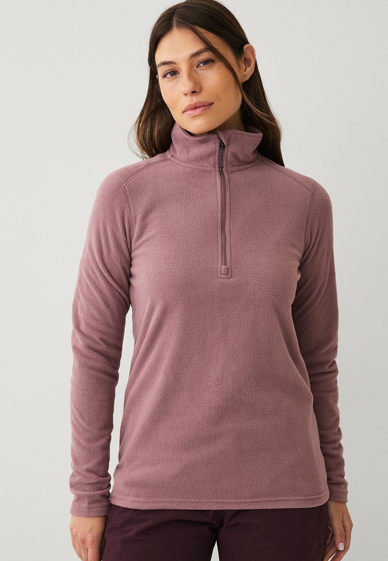 Fleece-pullover i mauve med halv-zip krave, lange ærmer og en blød tekstur. Har en rundet bund og ingen synlig branding.