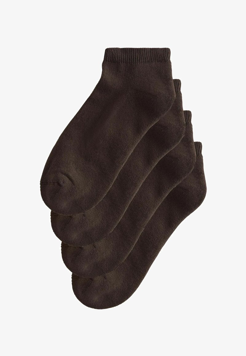 Quatre paires de chaussettes de cheville noires unies empilées proprement sur un fond blanc.