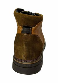 Botín de ante marrón con acentos de cuero, puntera redonda y suela de goma texturizada. Presenta costuras y una pestaña en la parte trasera.