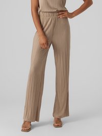Bež jumpsuit z nabranimi hlačami, sproščenim krojem, elastičnim pasom in širokimi hlačami. Ponaša se z navpičnim rebrastim teksturiranjem in minimalističnim oblikovanjem.