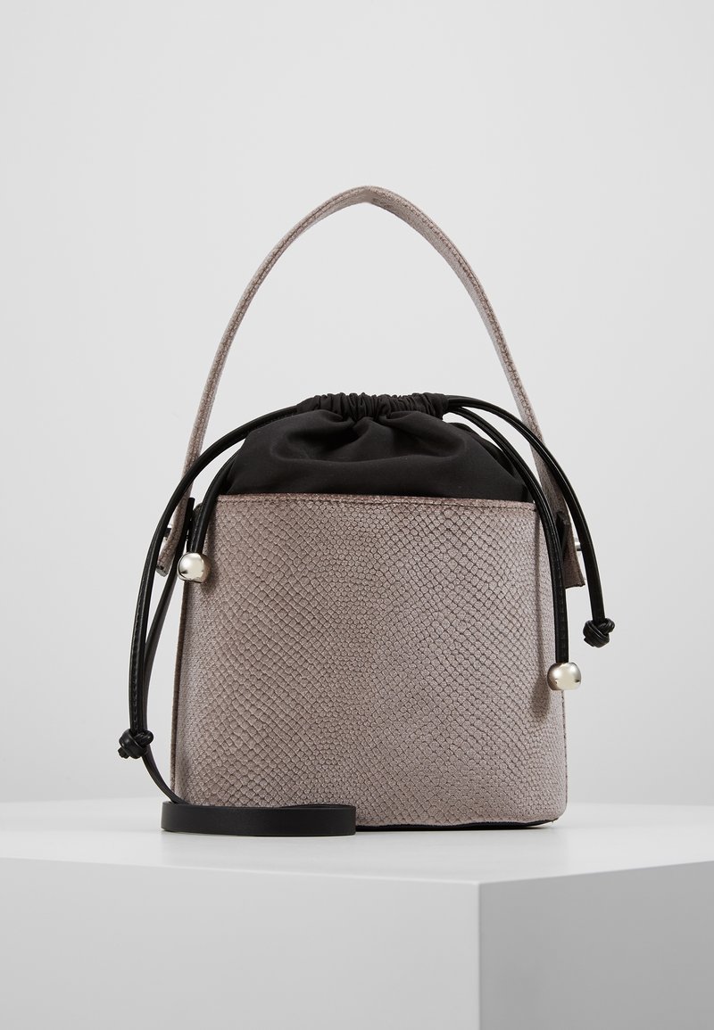 Szara beżowa torebka o fakturze z czarnym ściągaczem na górze, krótkim uchwytem i dekoracyjnymi perłami, charakteryzująca się wyraźnym, kwadratowym kształtem.