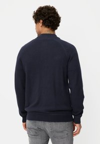 Navy crew-neck sweater with long sleeves, ribbed cuffs and hem, made from a smooth knit material; features raglan shoulder seams.