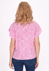 Kortärmad topp i rosa tyg med paisleymönster. Lätt avslappnad passform med rund halsringning, slät textur och böjd nederkant.