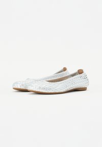 Ballerines argentées tressées avec un bout rond et une semelle plate, présentant un tissu texturé et une doublure intérieure douce.