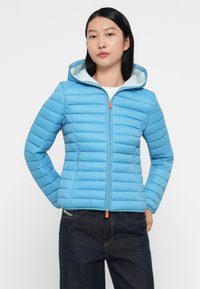 Blauwe pufferjack met horizontaal gestikt ontwerp, volledige rits en capuchon, met een oranje ritsen trekker en lichtblauwe voering.