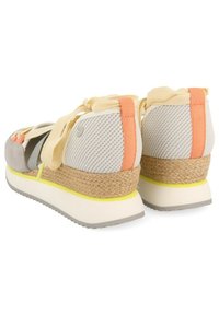 Baskets grises et blanches avec une semelle intermédiaire en jute tissé, une tige en mesh et des accents pastel avec des lacets en ruban croisés.