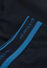 Schwarzer Stoff mit glatter Textur hat einen breiten Bund in Dunkelblau, akzentuiert mit einem hellblauen Streifen und Markentext.