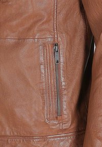 Braune Lederjacke mit einer seitlichen Reißverschlusstasche, glatter Textur und dezenten Nähte entlang der Säume.