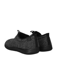 Grijze instap schoenen van zacht materiaal met zwarte rubberen zolen, met een minimalistisch ontwerp en een kleine hielhandgreep voor gemakkelijk aan- en uittrekken.