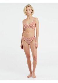 Prugasti bikini set u crvenoj i bijeloj boji. Gornji dio ima trokutan oblik s tankim trakama, a donji dio ima klasičan kroj.