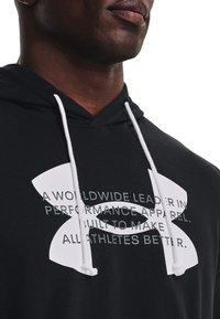 Felpa nera con cappuccio e coulisse bianche, caratterizzata da testo grafico audace e logo. Tessuto morbido, vestibilità comoda e tasca a marsupio.