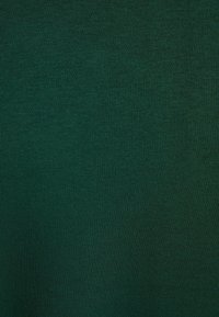 Tela textil verde con una textura suave y uniforme. Presenta un patrón de tejido consistente, sin patrones ni detalles notables.