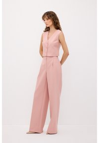 Roze cropped vest met drie knopen, gecombineerd met wijde pijpen, beiden gemaakt van een gladde stof, met een op maat gemaakte pasvorm en een minimaal ontwerp.