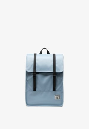 Sac à dos bleu clair avec un rabat, doté de sangles et de boucles en cuir noir. Comprend une petite poche avant avec un logo de marque. Matériau durable.