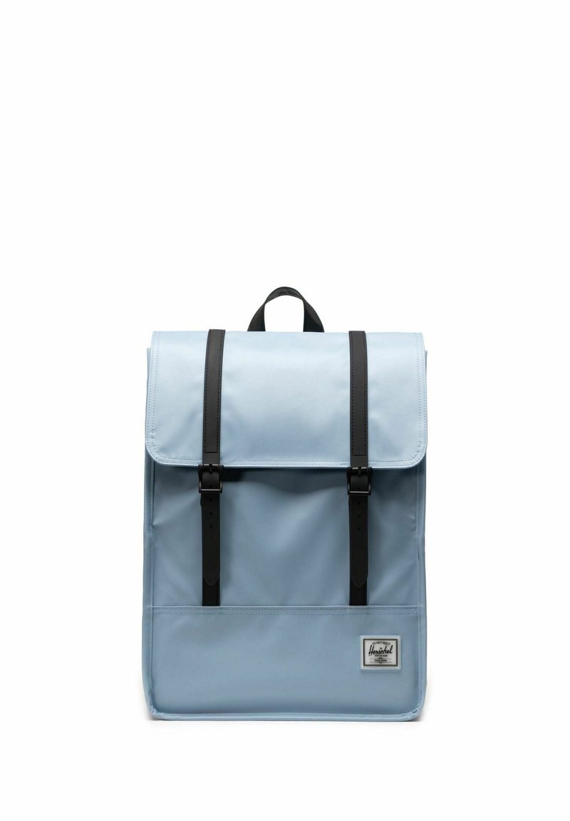 Sac à dos bleu clair avec un rabat, doté de sangles et de boucles en cuir noir. Comprend une petite poche avant avec un logo de marque. Matériau durable.