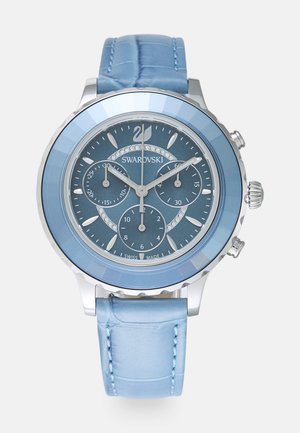 Blue chronograph watch featuring a silver stainless steel case, a glossy blue bezel, and a textured light blue leather strap.