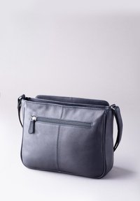 Dark blue leather handbag with a textured finish, featuring a front zip pocket, adjustable strap, and a simple rectangular shape.