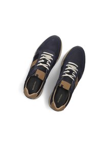 Marineblauwe sneakers met beige accenten, voorzien van witte veters, een gestructureerd oppervlak en een rubberen zool. Kenmerkende ontwerpelementen zijn zijkruislijnen.