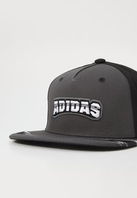 Μαύρο και γκρι καπέλο snapback με επίπεδο γείσο; διαθέτει κεντημένο λογότυπο "ADIDAS" σε λευκό; το ύφασμα είναι λείο με απαλή υφή.