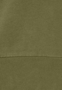 Tejido de punto verde oliva, textura suave con dobladillo acanalado, patrón de superficie uniforme, peso medio, adecuado para ropa casual o para estratificar.