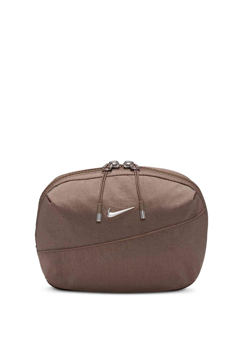 Hnedá taška Nike s hladkou textúrou, zipsovým uzatváraním a strieborným logom. Obsahuje sťahovacie šnúrky a elegantný zakrivený dizajn.