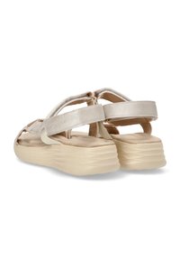 Sandalias beige con una suela texturizada y acolchada, y tiras superpuestas con un acabado brillante, diseñadas para la comodidad y el soporte.