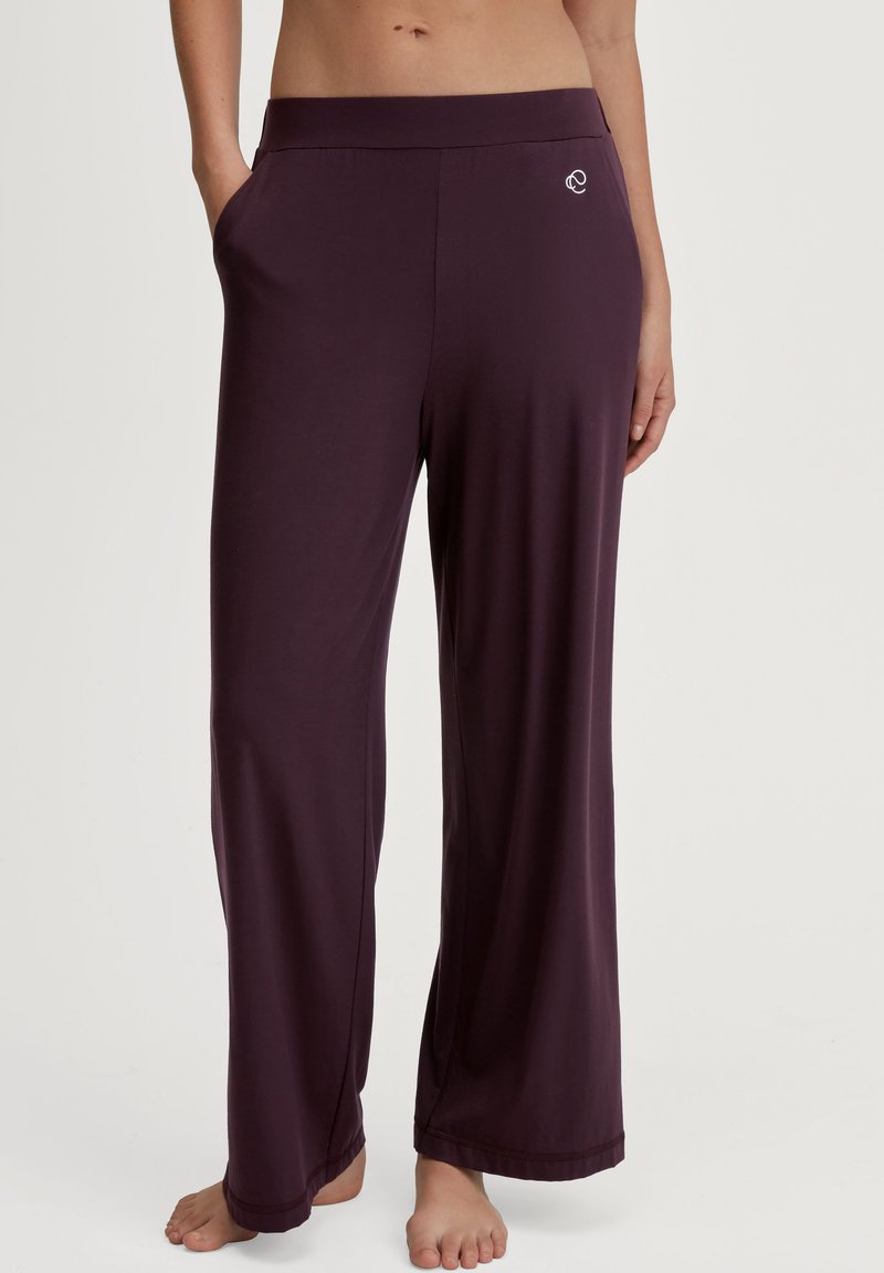 Pruimenkleurige drawstring broek in een soepele stof met een wijde pijpdesign. Voorzien van zijzakken en een klein logo vlakbij de tailleband.