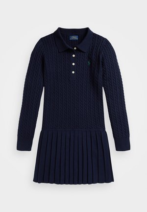 Mørkeblå strikket kjole med lange ermer, ribbestrikket krage, placket med tre knapper, plissert skjørt og brodert logo på brystet.