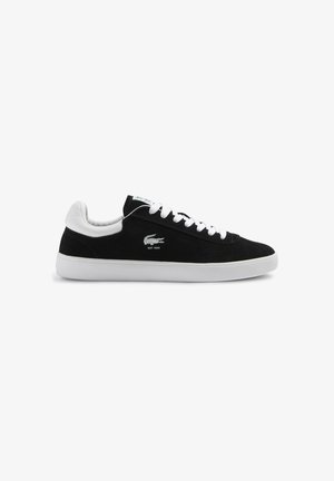 Črne semiš superge z belimi usnjenimi detajli, belimi vezalkami in teksturirano gumijasto podplato. Lacoste logo izvezen blizu pete.