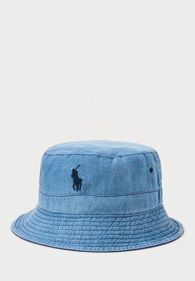 Denim kapa s plavim tijelom, mornarsko plavim izvezenim logom i širokim, ravnim rubom; sadrži teksturiranu tkaninu.