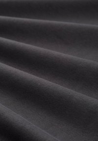 Tessuto grigio scuro con una superficie liscia, che mostra pieghe morbide e un leggero lucido, adatto a varie applicazioni tessili.